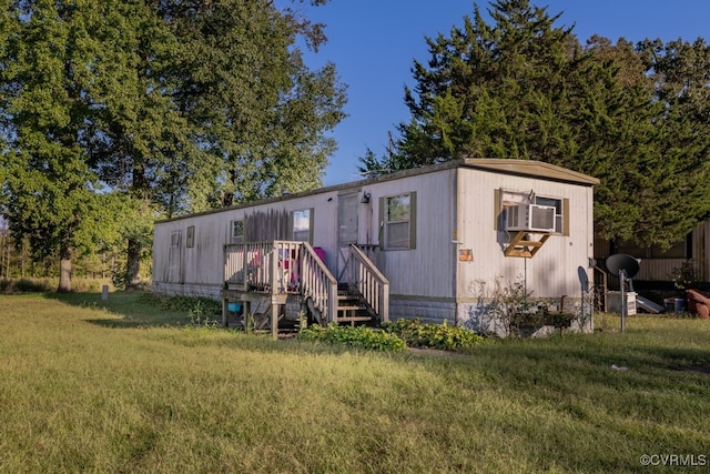 view of front of house with cooling unit and a front lawn