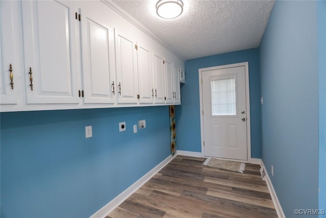 laundry area with electric dryer hookup, wood-type flooring, cabinets, and a textured ceiling