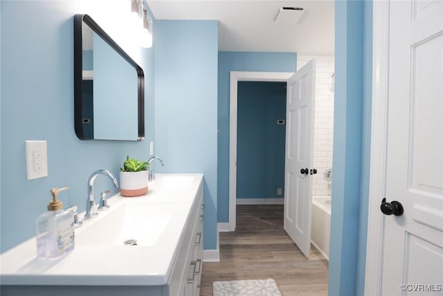 bathroom featuring a washtub, vanity, and wood-type flooring