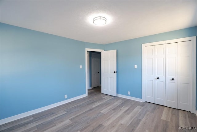 unfurnished bedroom featuring light wood-type flooring and a closet