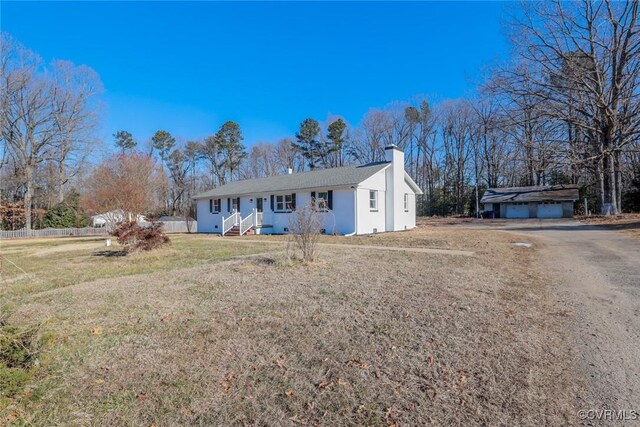 view of front of house with an outbuilding, a garage, and a front yard