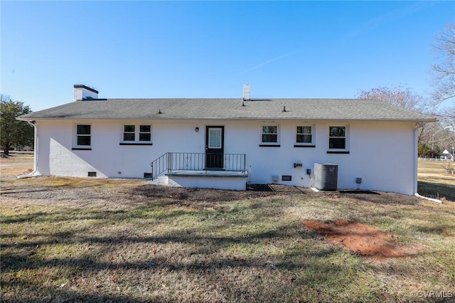 rear view of property with a lawn and central air condition unit