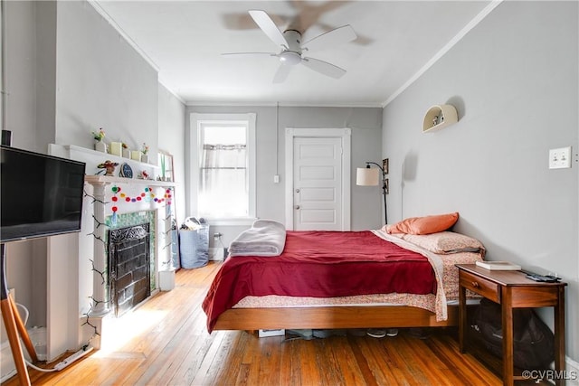 bedroom with crown molding, ceiling fan, and wood-type flooring