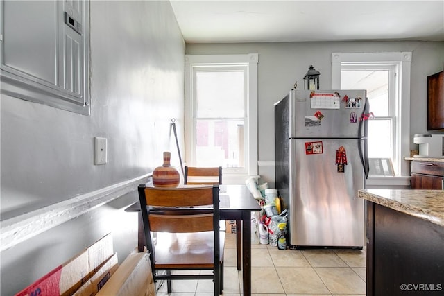 kitchen featuring light tile patterned floors and stainless steel fridge