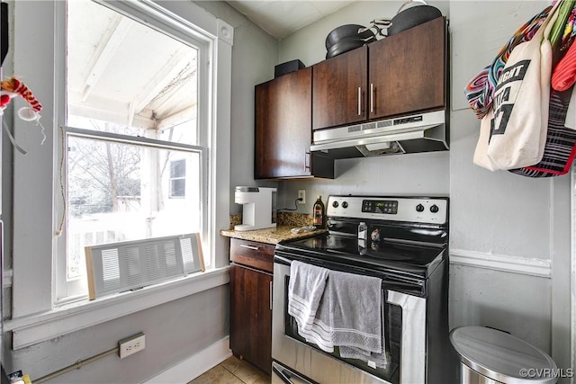 kitchen featuring dark brown cabinets, light tile patterned floors, and stainless steel range with electric stovetop