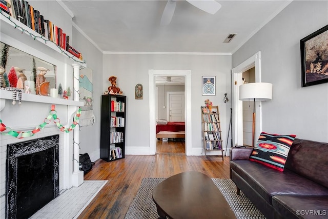 living room featuring crown molding, hardwood / wood-style floors, and ceiling fan