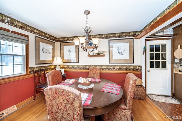 dining room with hardwood / wood-style floors and a notable chandelier