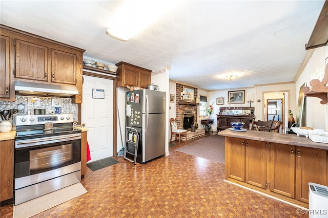 kitchen with crown molding, appliances with stainless steel finishes, a fireplace, and backsplash