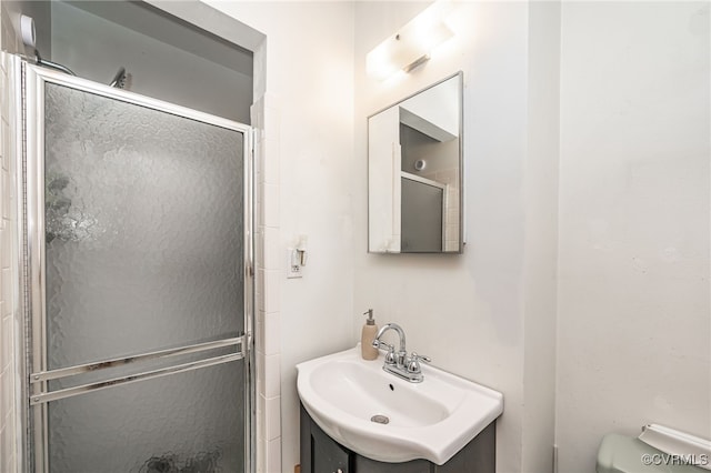 bathroom featuring vanity, toilet, and walk in shower