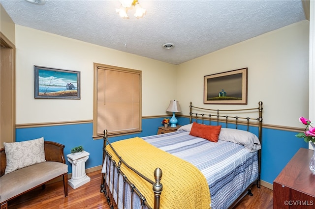 bedroom with hardwood / wood-style flooring and a textured ceiling