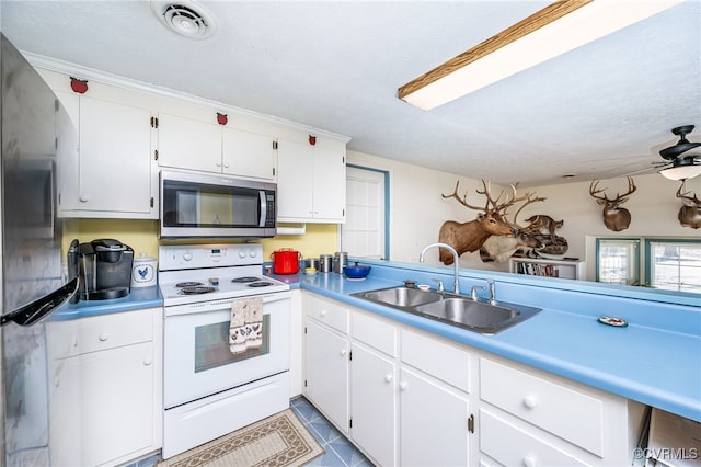 kitchen with sink, kitchen peninsula, white cabinets, and appliances with stainless steel finishes