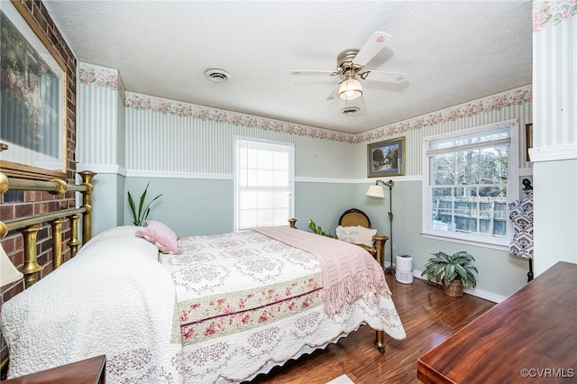 bedroom featuring hardwood / wood-style floors, a textured ceiling, and ceiling fan