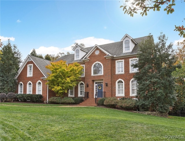 colonial-style house featuring a front yard