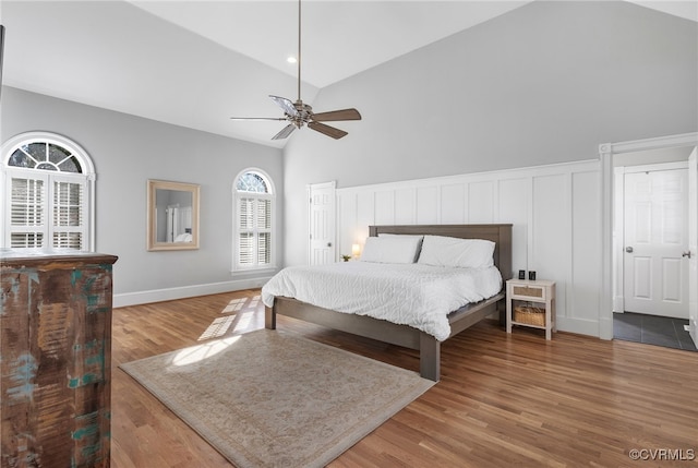 bedroom with ceiling fan, wood-type flooring, and vaulted ceiling