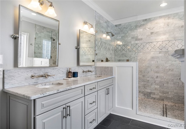 bathroom featuring tasteful backsplash, vanity, tiled shower, crown molding, and tile patterned floors