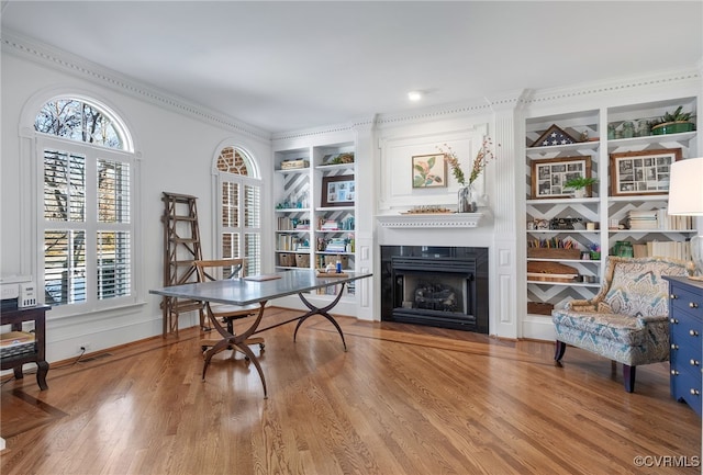 office with plenty of natural light, light wood-type flooring, and built in shelves