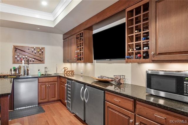 kitchen with stainless steel appliances, crown molding, sink, and dark stone counters