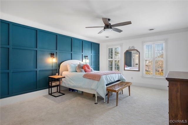 carpeted bedroom with ornamental molding and ceiling fan