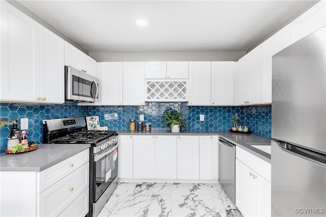 kitchen with appliances with stainless steel finishes, decorative backsplash, and white cabinets