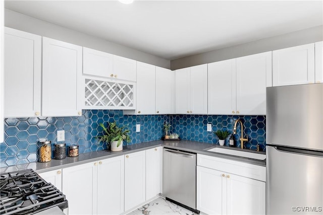 kitchen featuring appliances with stainless steel finishes, sink, white cabinets, and backsplash