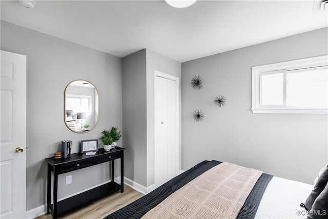 bedroom with light hardwood / wood-style floors and multiple windows