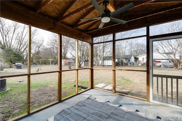 unfurnished sunroom featuring a wealth of natural light, lofted ceiling with beams, wooden ceiling, and ceiling fan