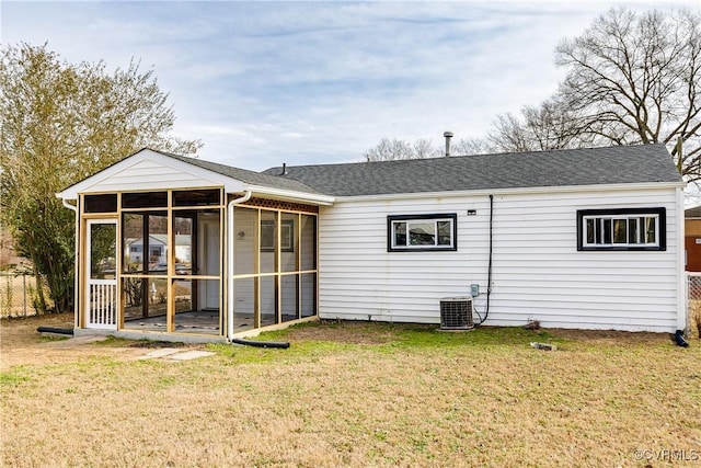 back of property with central AC, a yard, and a sunroom