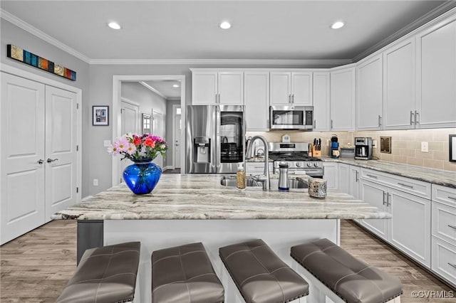 kitchen with light wood-style floors, a breakfast bar area, and stainless steel appliances