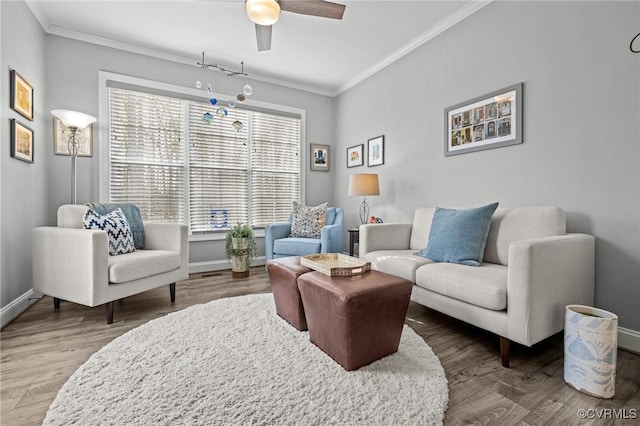 sitting room featuring baseboards, wood finished floors, and crown molding