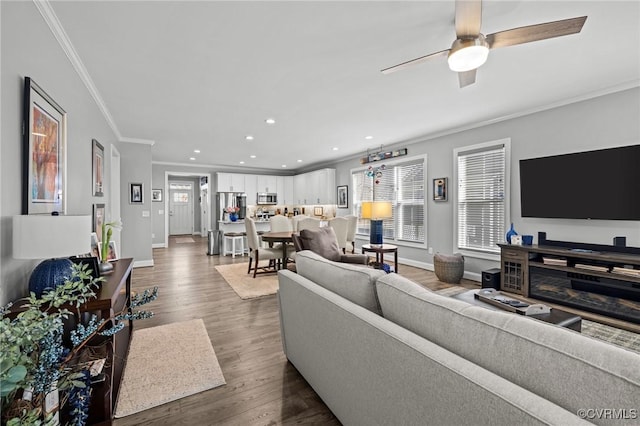 living room featuring crown molding, recessed lighting, dark wood-type flooring, a ceiling fan, and baseboards