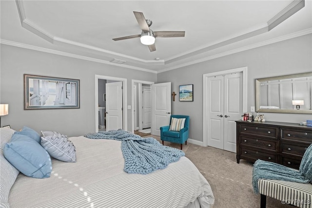 bedroom with a tray ceiling, a closet, light colored carpet, and crown molding