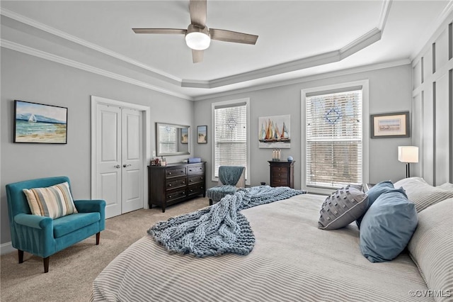 bedroom featuring a raised ceiling, light carpet, and crown molding