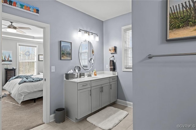 ensuite bathroom with a ceiling fan, vanity, ensuite bath, baseboards, and tile patterned floors