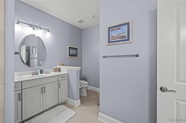 bathroom featuring visible vents, toilet, vanity, tile patterned flooring, and baseboards