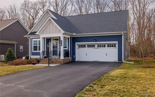 view of front of home featuring board and batten siding, roof with shingles, a garage, and aphalt driveway