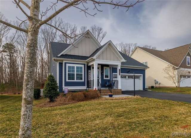 craftsman house with board and batten siding, a front yard, an attached garage, and aphalt driveway