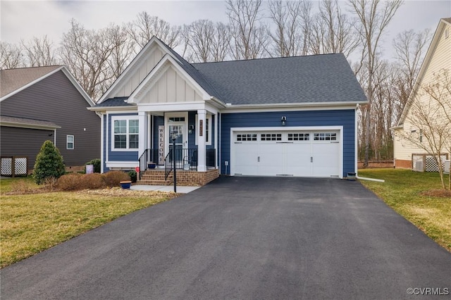 view of front facade featuring a garage, driveway, roof with shingles, a front lawn, and board and batten siding