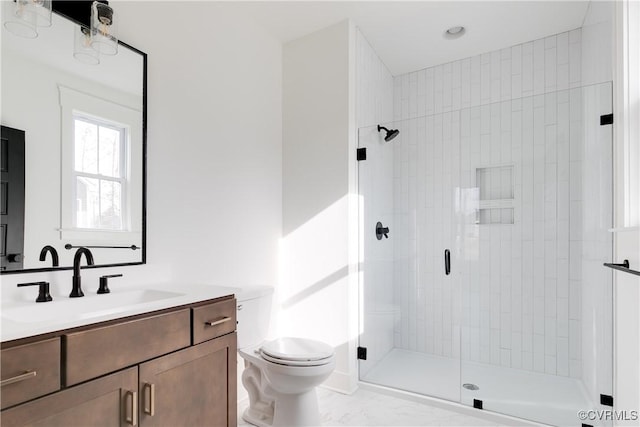 bathroom featuring a shower with door, vanity, and toilet