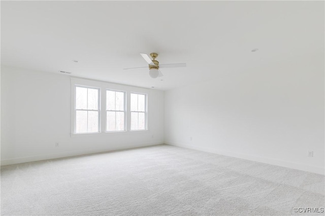 carpeted spare room featuring ceiling fan