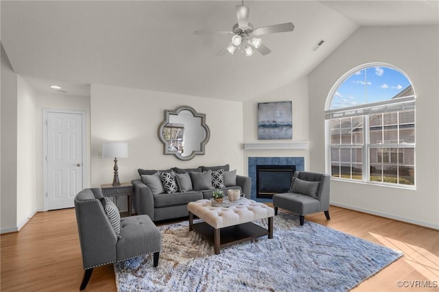 living room with lofted ceiling, hardwood / wood-style flooring, a fireplace, and ceiling fan