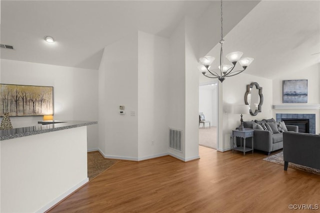 living room with hardwood / wood-style flooring, a fireplace, and vaulted ceiling