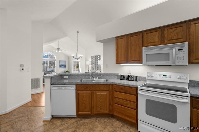 kitchen with pendant lighting, lofted ceiling, sink, kitchen peninsula, and white appliances