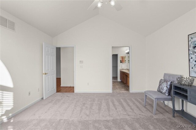 sitting room with light carpet, vaulted ceiling, and ceiling fan