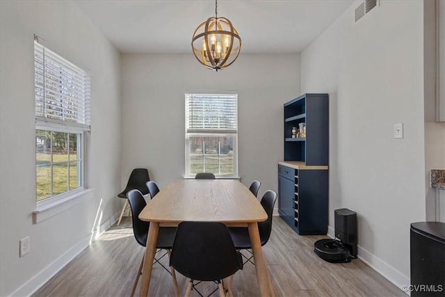 dining area featuring a wealth of natural light, visible vents, baseboards, and wood finished floors