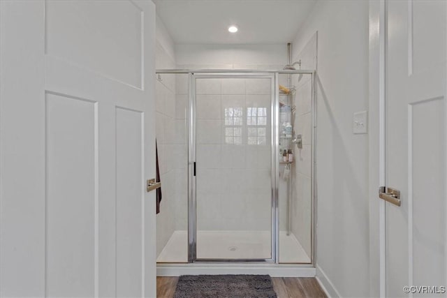 bathroom with a stall shower and wood finished floors