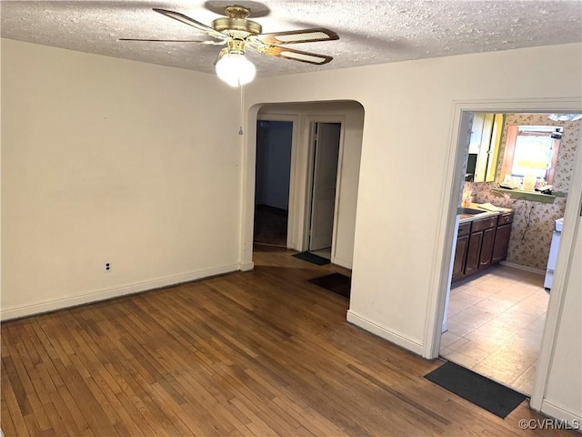 spare room featuring ceiling fan, a textured ceiling, and light hardwood / wood-style floors