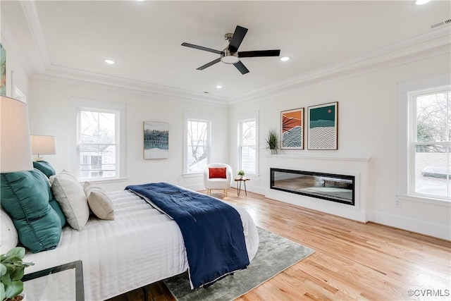 bedroom featuring wood-type flooring, ornamental molding, and ceiling fan