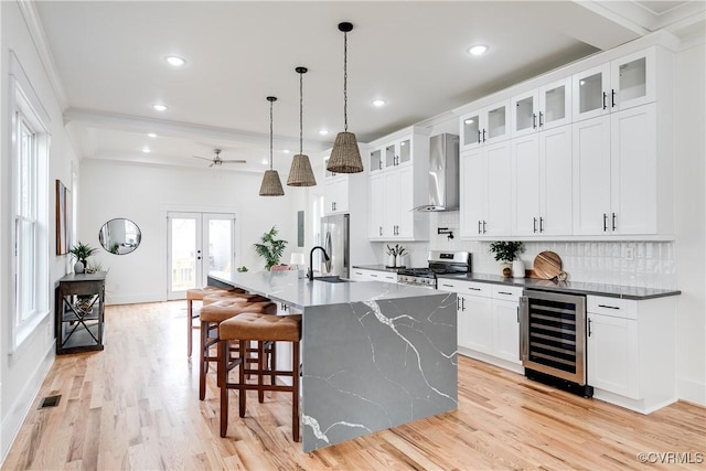 511 N 33rd St, Richmond, VA 23223 - kitchen with wine cooler, stainless steel appliances, wall chimney exhaust hood, a sink, and tasteful backsplash