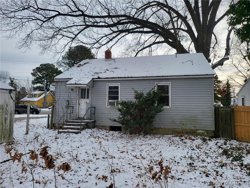 snow covered rear of property with cooling unit