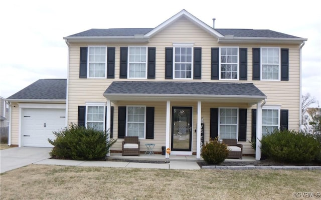 view of front facade featuring a porch, a garage, and a front lawn